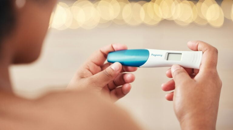Pregnancy test, woman and hands check results of medical information at home. Closeup, fertility st